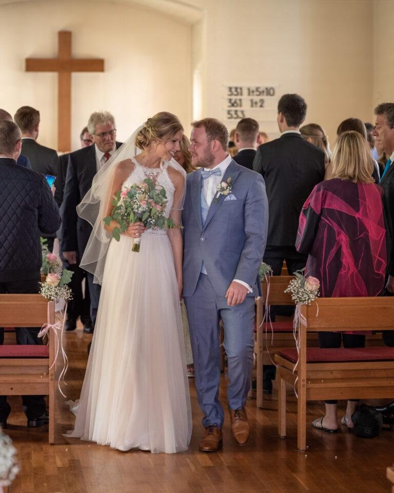 Brautpaar zieht nach der kirchlichen Trauung durch den Mittelgang – Hochzeit Miriam & Pascal