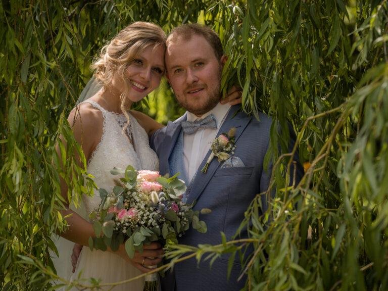 Brautpaar mit Brautstrauß unter einer Trauerweide – Brautpaarshooting Miriam & Pascal