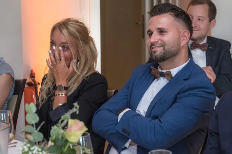 Gäste lachen bei einer Rede am Tisch – Hochzeitsfeier Miriam & Pascal