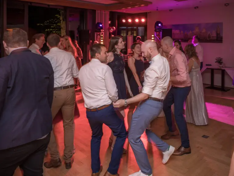 Gäste tanzen im bunten Partylicht – Hochzeitsfeier Miriam & Pascal