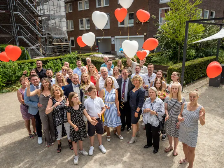Großes Gruppenfoto mit roten und weißen Luftballons – Hochzeit Miriam & Pascal