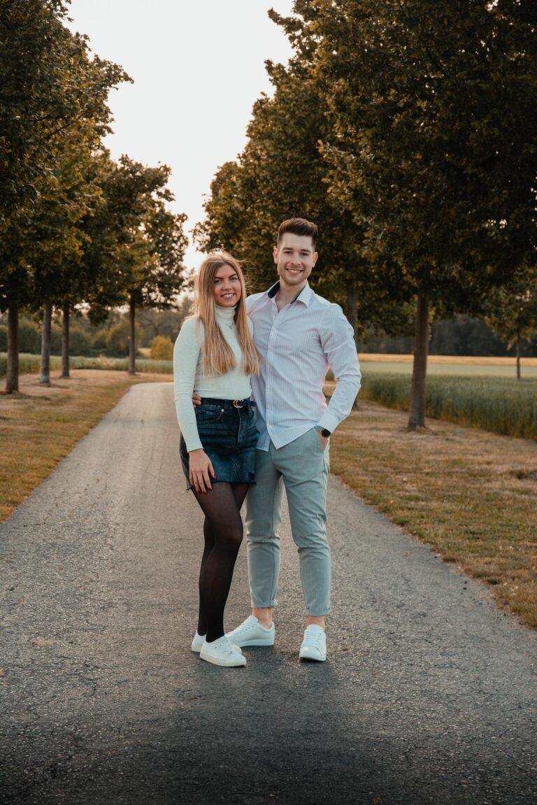 Paar geht Hand in Hand über einen Weg im Grünen – Paarfotos Münster