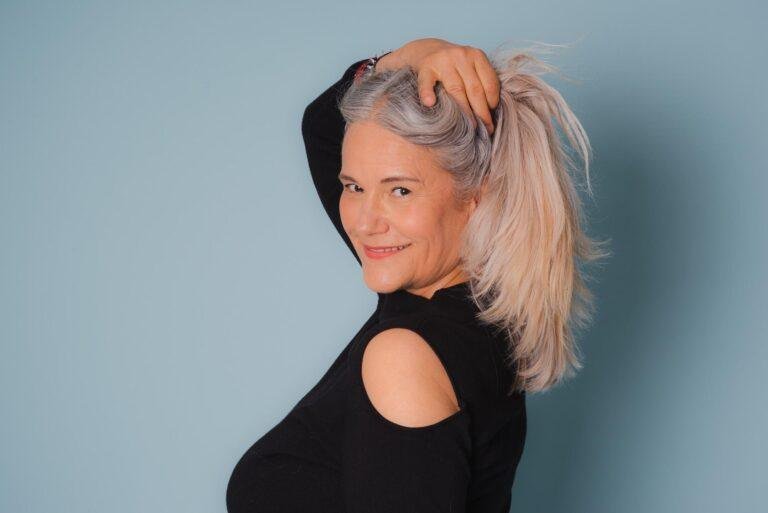 Frau mit blonden Haaren posiert vor hellblauem Hintergrund – Portraitfotos SNDR Photos Münster