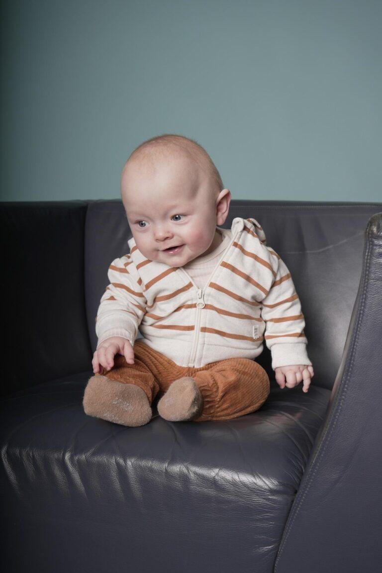 Baby im gestreiften Pullover sitzt auf einem Ledersessel – Babyfotos SNDR Photos Münster