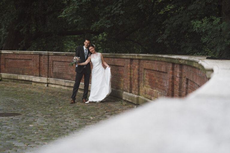 Web-14 Brautpaar an einer Backsteinbrüstung im Park – Brautpaarshooting Bernadette & André am Schloss Münster
