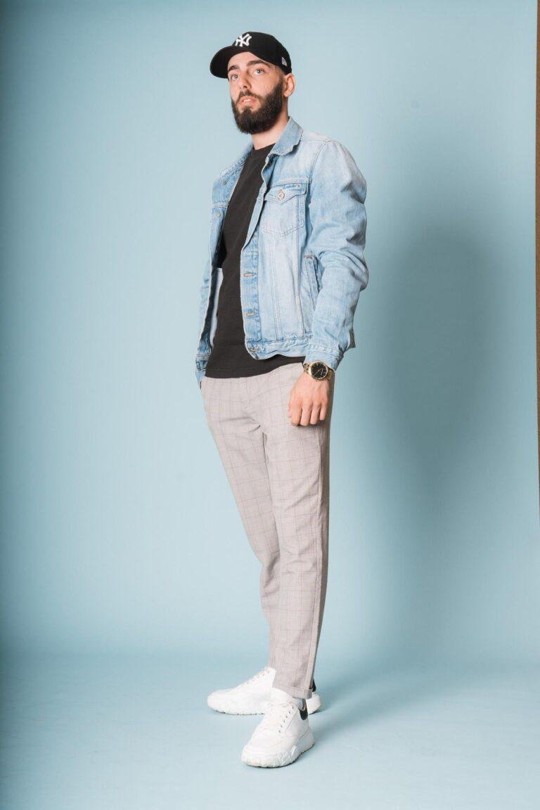 Mann in Jeansjacke vor hellem Hintergrund – lockeres Portrait von SNDR Photos