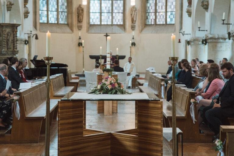 Web-26 Blick über die Kirchenbänke zum geschmückten Altar – kirchliche Trauung Bernadette & André