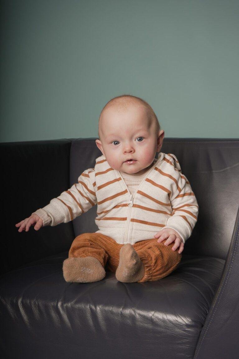 Baby im gestreiften Pullover auf einem Ledersessel – Babyfotos SNDR Photos Münster