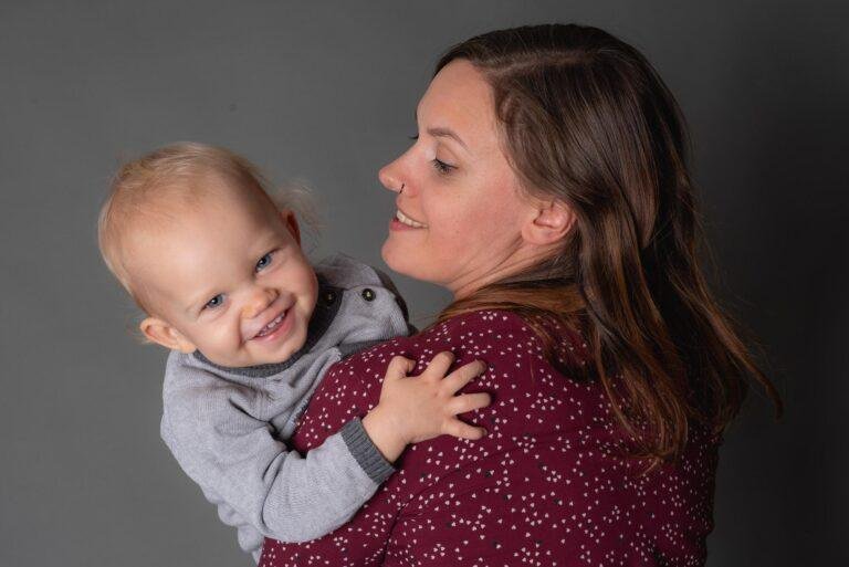 Mutter kuschelt mit ihrem lachenden Kleinkind – Kinderfotos SNDR Photos Münster
