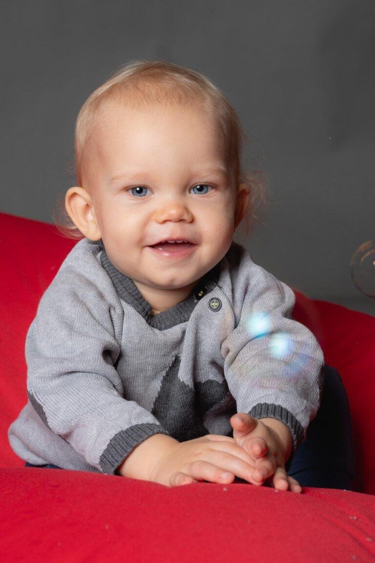 Kleinkind lacht auf einem roten Sitzsack – Kinderfotos SNDR Photos Münster