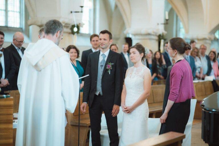 Web-30 Pfarrer und Brautpaar am Altar während der Trauung – kirchliche Trauung Bernadette & André