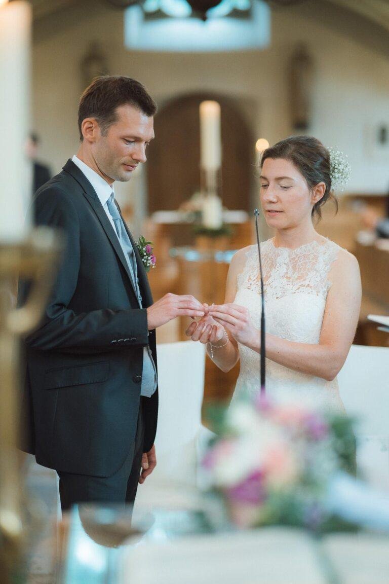 Web-32 Brautpaar steckt sich die Ringe an – kirchliche Trauung Bernadette & André