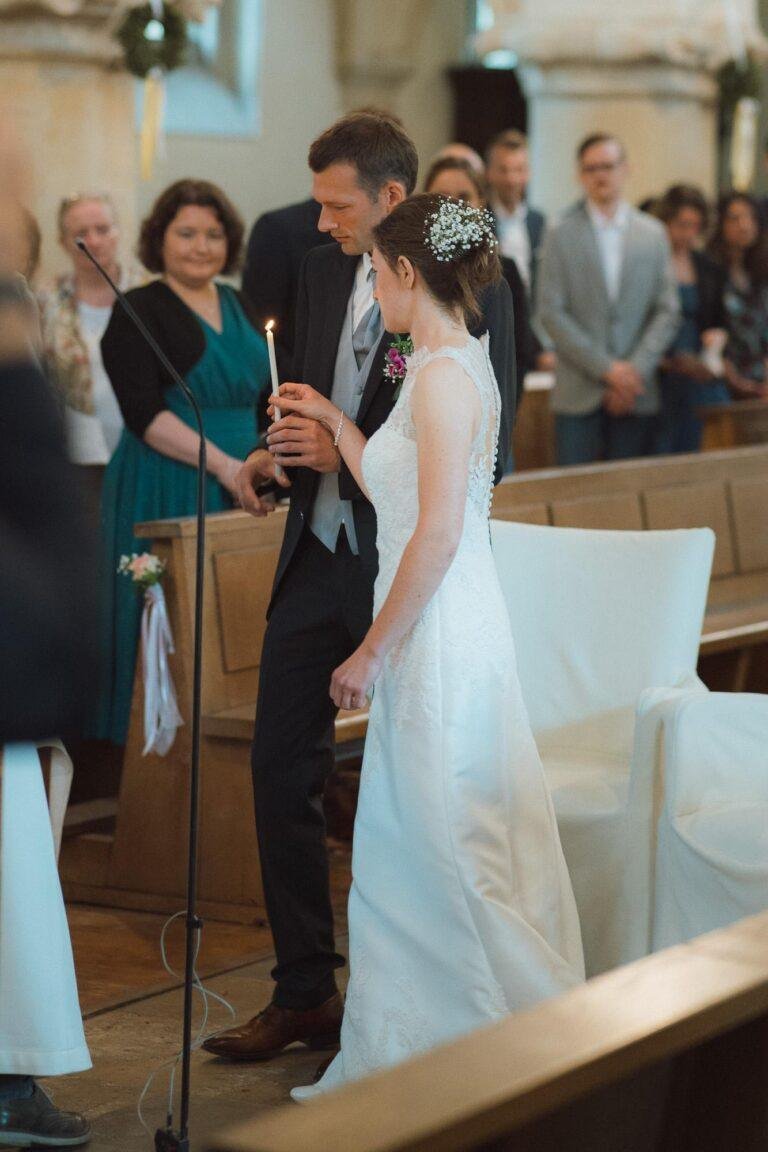 Web-35 Brautpaar steht im Kirchenschiff, Gäste schauen zu – kirchliche Trauung Bernadette & André