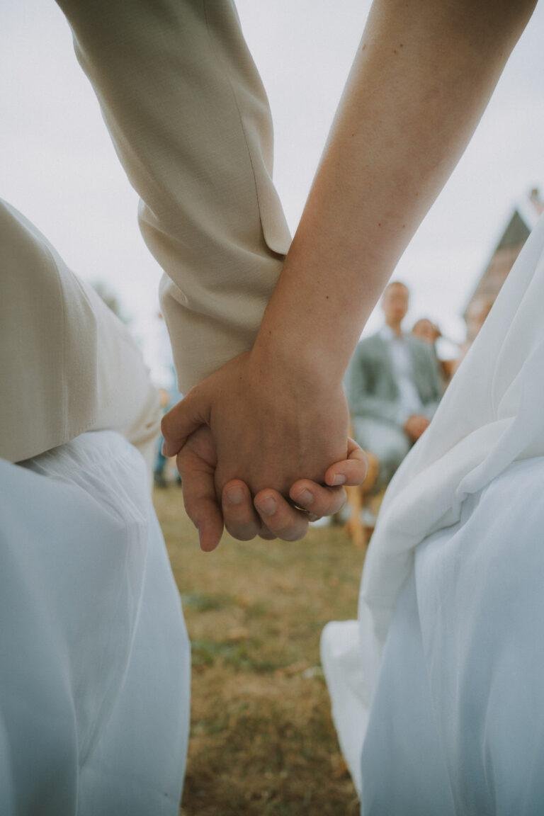 Brautpaar hält sich bei der freien Trauung an den Händen – Hochzeit Nora & Simon