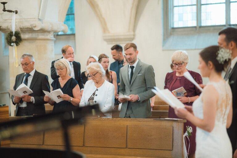 Web-39 Braut liest während der Trauung, Gäste hören zu – kirchliche Trauung Bernadette & André
