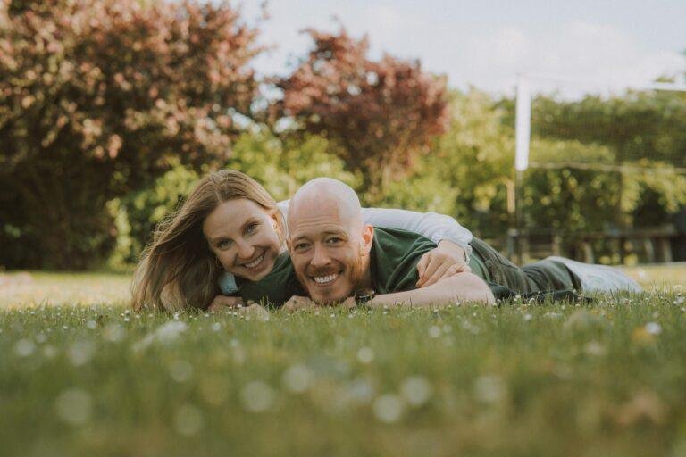 Paar liegt lachend im Gras – Paarfotoshooting SNDR Photos Münster