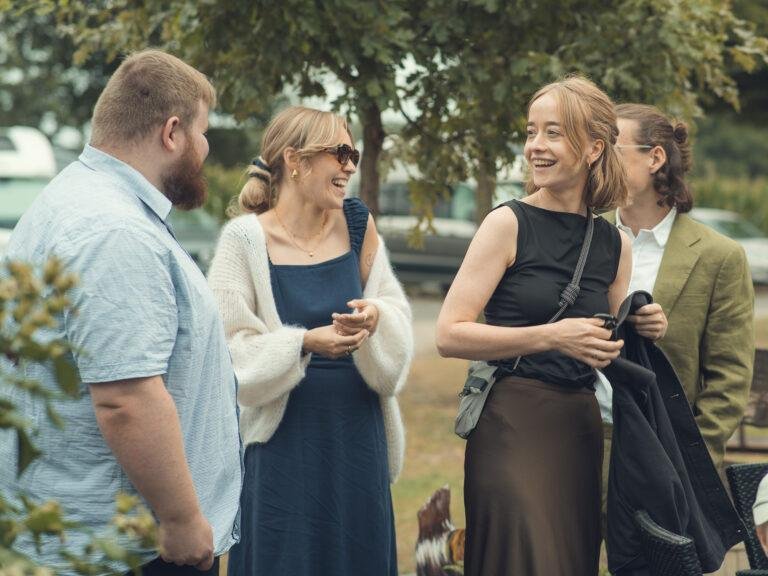 Gäste lachen gemeinsam im Garten – Hochzeitsfeier Nora & Simon