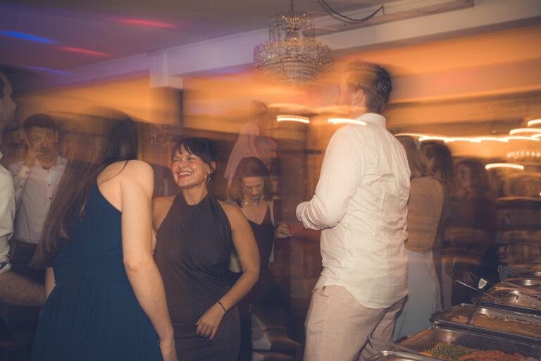 Web-42 Gäste tanzen im farbigen Partylicht, Langzeitbelichtung – Hochzeitsfeier Renée & Patrick im Café Nobis