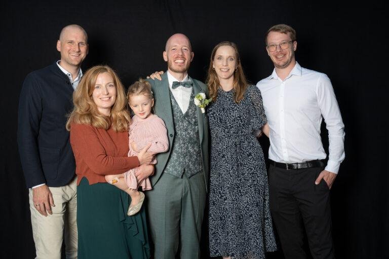 Web-45 Große Familie mit Kleinkind posiert vor schwarzem Hintergrund – Hochzeit Renée & Patrick, Fotobox-Porträt