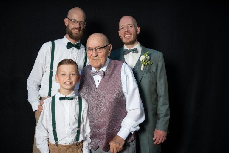 Web-46 Drei Generationen posieren lachend vor schwarzem Hintergrund – Hochzeit Renée & Patrick, Fotobox-Porträt