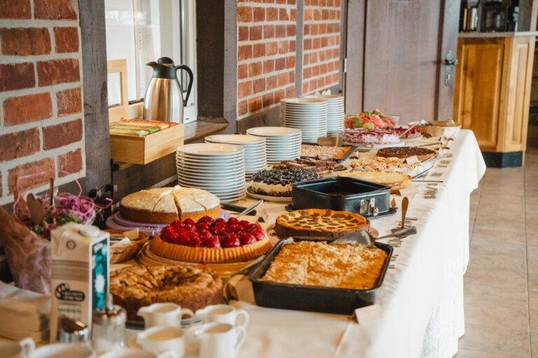 Buffet mit Kuchen und Speisen auf langen Tischen – Hochzeitsfeier Nora & Simon