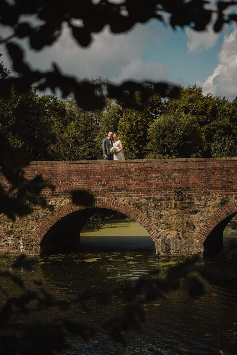 Web-5 Brautpaar auf einer alten Steinbrücke, durch Zweige fotografiert – Brautpaarshooting Renée & Patrick