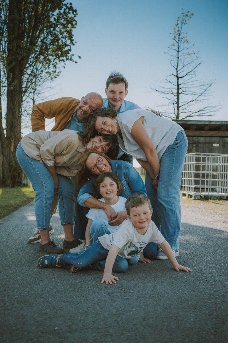 Familie tobt lachend zusammen auf dem Boden – Familienfotoshooting SNDR Photos Münster