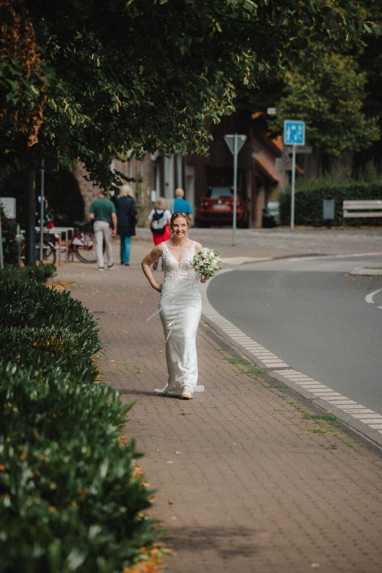 Web-50 Braut geht allein über einen Gehweg in der Stadt – Standesamt Renée & Patrick