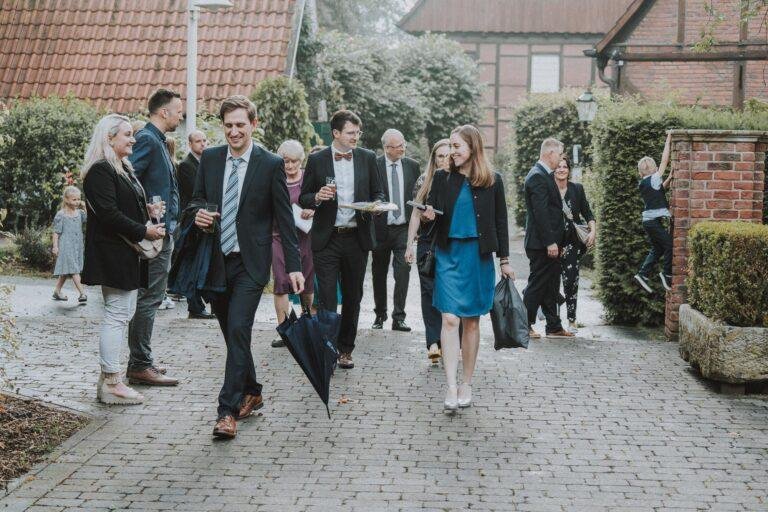 Web-62 Gäste gehen gemeinsam über einen Innenhof – Hochzeitsfeier Bernadette & André