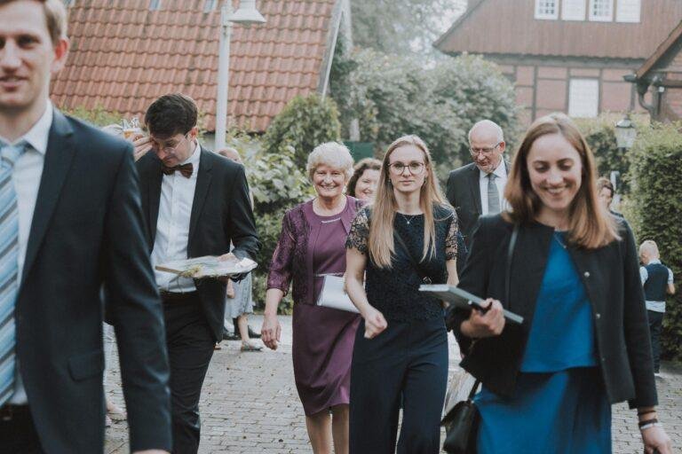 Web-63 Gäste kommen lachend über den Hof – Hochzeitsfeier Bernadette & André