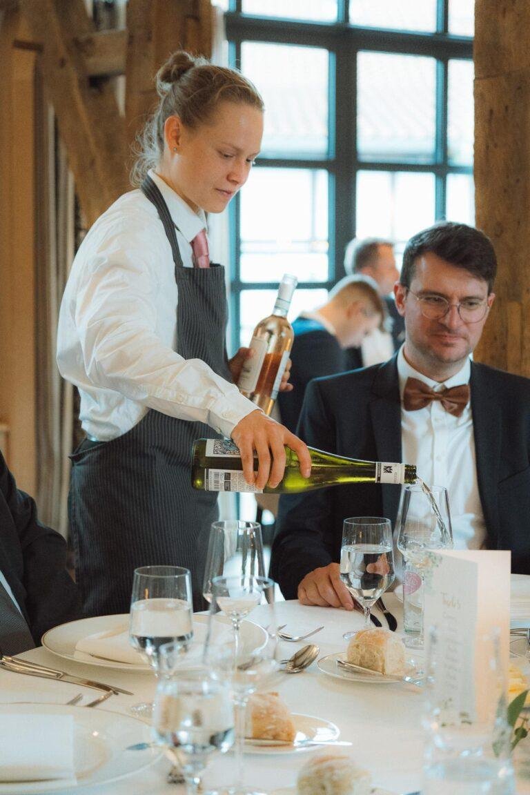 Web-67 Kellnerin schenkt Wein am Tisch ein – Hochzeitsfeier Bernadette & André