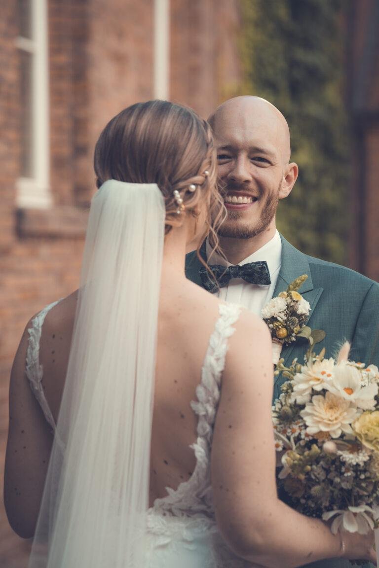 Web-7 Bräutigam lacht die Braut mit Schleier an – Brautpaarshooting Renée & Patrick