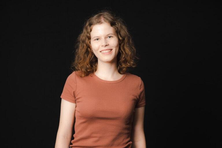 Junge Frau mit Locken vor schwarzem Hintergrund – Portraitfotos SNDR Photos Münster