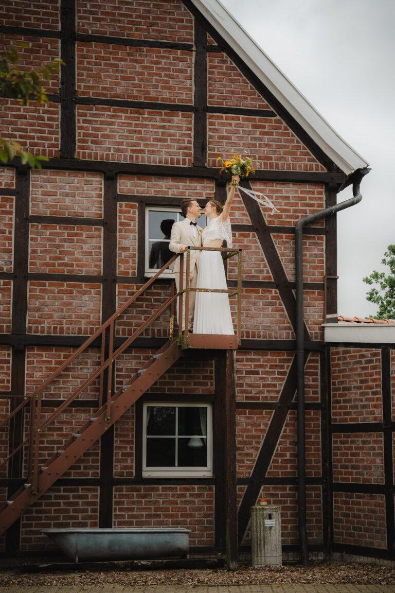 Brautpaar auf der Außentreppe eines Fachwerkhauses – Brautpaarshooting Nora & Simon