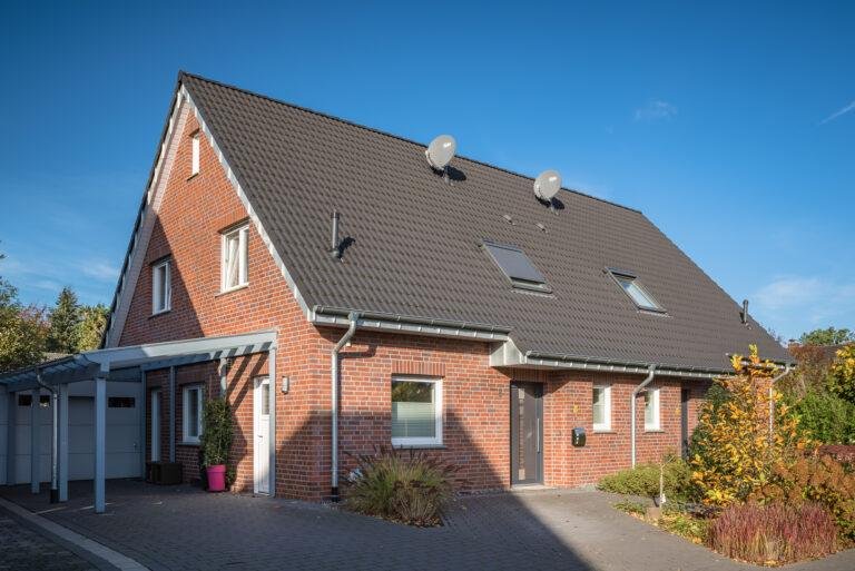 Rotes Backstein-Einfamilienhaus mit Garten im Sonnenschein – Business-Fotografie SNDR Photos Münster