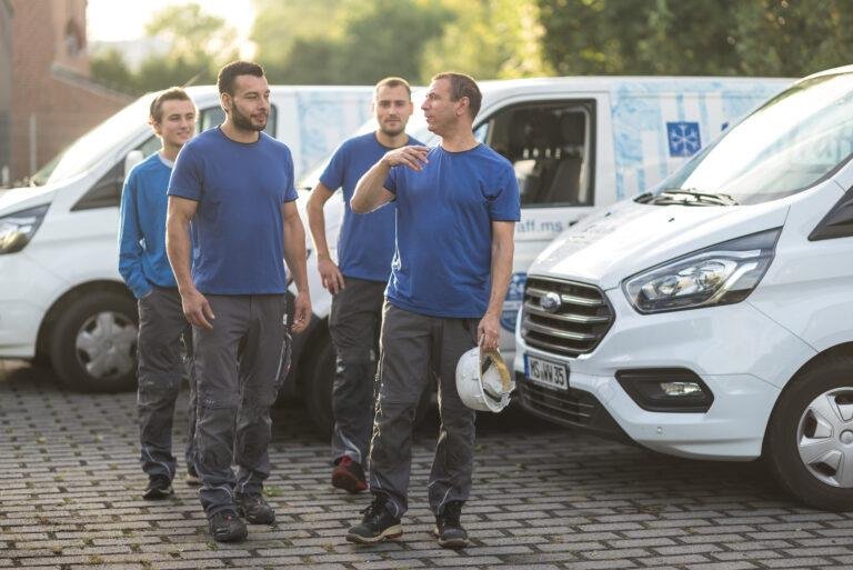 Handwerker-Team geht vor den Firmenwagen entlang – Business-Fotografie SNDR Photos Münster
