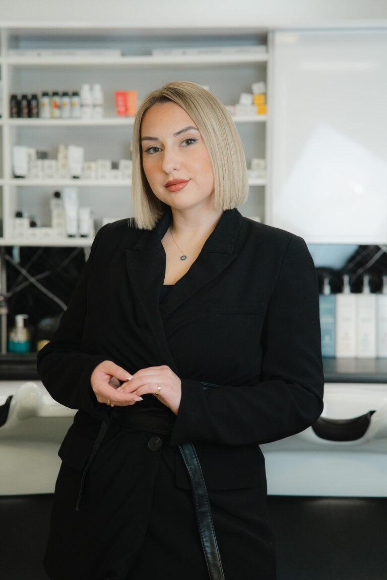 Friseurin im schwarzen Blazer steht im Salon – Business-Fotografie SNDR Photos Münster
