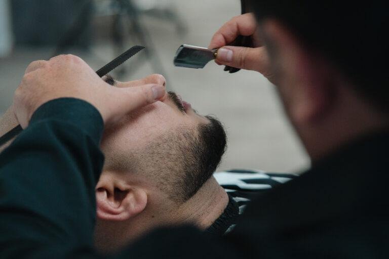 Barbier rasiert einem Kunden den Bart, Nahaufnahme – Business-Fotografie SNDR Photos Münster